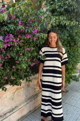 Vestido midi tejido a rayas horizontales en color crudo y negro, con mangas cortas y corte recto.