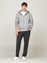 Buzo gris con capucha Tommy Hilfiger, con cierre de cremallera, bolsillos tipo canguro, forro de piel sintética y logo bordado en el pecho.