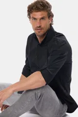 Camisa negra de algodón con mangas largas y cuello clásico.