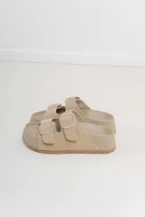 Sandalias planas color beige con doble tira y hebillas ajustables.