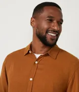 Camisa negra de lino con corte clásico, cuello camisero y mangas largas. Cierre frontal con botones.