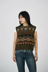 Chaleco corto de punto color verde militar con estampado de calaveras y motivos geométricos en tonos marrones, azules y rojos.