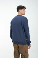 Buzo gris melange de corte clásico, con cuello redondo y mangas largas.