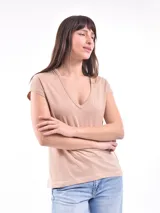Remera color beige con cuello en V y mangas cortas.