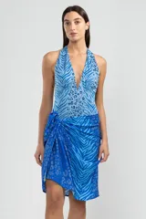 Traje de baño enterizo con estampado animal print en tonos de azul, con escote halter y espalda descubierta.