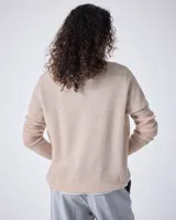 Sweater de cashmere color lila con cuello en V, corte oversize, mangas largas, hombros caídos y terminaciones acanaladas.