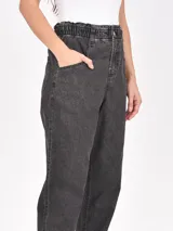 Pantalón jean negro con cintura elastizada y corte holgado.