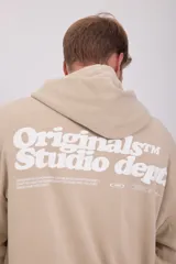 Canguro color arena con capucha y estampado en la espalda con la inscripción "Originals Studio dept", "Designed in Copenhagen. Established in nineteen ninety, Crafted aesthetics brought to you by Jack and Jones since nineteen ninety" y el número "1990".