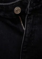 Pantalón de jean negro de tiro medio, corte flare y bajo deshilachado.