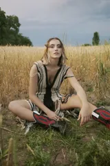 Vestido largo tejido al crochet con lurex, con diseño a rayas verticales en tonos beige y negro, y terminación con flecos.