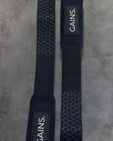 Straps de levantamiento de pesas color negro con logo "GAINS." en blanco.