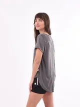Remera gris de corte relajado, con cuello redondo y manga corta, fabricada en material liviano.