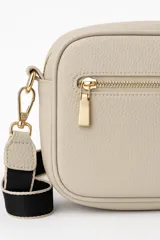 Bandolera negra de cuero sintético con correa ancha de tela color beige.