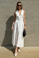 Vestido midi blanco de viscosa lyocell, con cuello camisero, sin mangas, abotonado al frente y abertura en la falda.