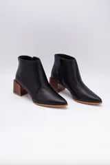 Botas cortas de cuero negro con punta fina y cierre lateral. Taco de madera de 6 cm.