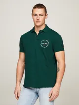 Chomba verde oscuro de piqué de algodón, corte regular, cuello clásico, cartera de dos botones, aberturas laterales y logo circular estampado en el pecho.