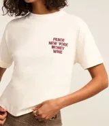 Remera blanca de algodón con corte boxy, cuello redondo y mangas cortas con dobladillo. Presenta un bordado en el pecho con la frase "PEACE NEW YORK MONEY WINE" en color borgoña.