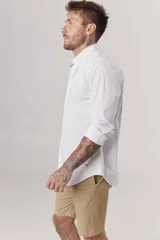 Camisa de hombre color crema, de corte clásico, con cuello abotonado y mangas largas.