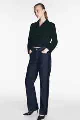 Pantalón de jean negro con corte recto, tiro medio, cinco bolsillos y detalle de banda lateral a contraste en color negro más oscuro.
