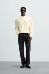 Jersey color crema de punto con textura, cuello redondo, manga larga y corte relaxed fit.
