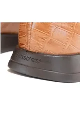 Botín Chelsea color caramelo de cuero vacuno liso con detalle texturizado efecto escama en el talón. Tiene inserciones elásticas laterales, forro 100% de cuero y plantilla de látex.