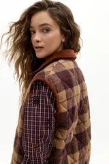 Chaleco oversized de paño de lana con estampado de cuadros en tonos beige, marrón y bordó. Presenta cuello y vivos en corduroy color caramelo, bolsillos plaqué frontales y cierre con botones a presión escondidos.