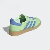 Championes Adidas modelo Handball Spezial con empeine de ante premium en color verde menta y detalles de cuero en color violeta. Presenta las icónicas tres tiras laterales, suela de goma color caramelo y cierre mediante cordones.
