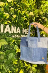 Bolso tipo tote bag confeccionado con retazos de jeans reciclados en tonos de azul y gris.