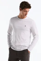 Remera de manga larga color blanco, con cuello redondo y un pequeño logo bordado de pingüino en el pecho.