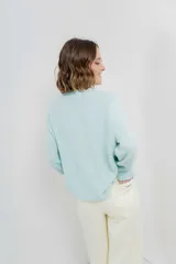 Sweater azul de punto medio, amplio, suave, con escote a la base y puños en mangas y en acabado inferior.