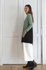 Vestido largo de morley fino, con corte asimétrico en bloques de color verde, negro y blanco, de mangas largas y calce amplio.