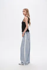 Pantalón de jean celeste de corte ancho con bolsillos y detalle de franja blanca en los laterales.