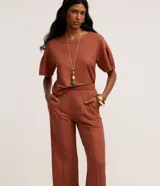 Pantalón recto color ladrillo, confeccionado en tejido orly con cintura elástica trabajada.