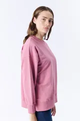 Buzo deportivo rosa de corte holgado y mangas largas.