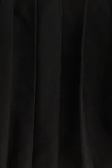 Minifalda negra tableada de punto con cintura elástica a rayas horizontales blancas y negras.