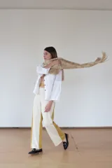 Pantalón de jersey de lana merino color lila y amarillo, de tiro medio y silueta holgada. Se ajusta con un cinturón del mismo tejido que se ata en la espalda.