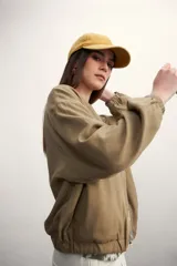 Chaqueta bomber negra con cierre frontal dorado y mangas largas con puños elásticos.