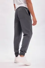 Pantalón deportivo tipo jogger color gris oscuro, con cintura elástica y cordón ajustable.