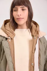 Campera acolchada reversible color verde militar, con capucha y cierre frontal con botones a presión.
