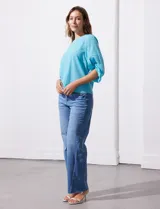 Blusa de gasa color blanco con estampado de hojas verdes, de mangas 3/4 abullonadas con puños elásticos.