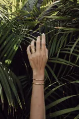 Brazalete rígido abierto de metal color plateado con textura irregular.