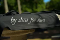 Chomba negra de corte cuadrado con cuello polo y mangas cortas. Presenta un escudo estampado en el pecho con diseño de fútbol retro y la palabra 'boxed' estampada en el frente.