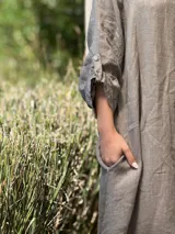 Vestido camisero amplio y largo de lino color azul, con botones de nácar, cuello camisero y bolsillos laterales.