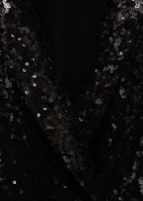 Mono corto negro con lentejuelas, cuello con solapa, sin mangas y bolsillos de ribete.