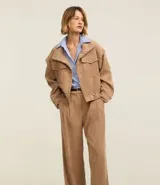 Pantalón recto de cintura alta, confeccionado en terciopelo cotelé color beige, con trabillas en la cintura, cierre tradicional y bolsillos delanteros.