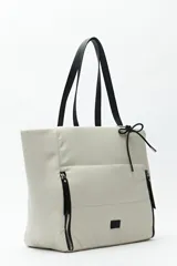 Bolso tote negro de nylon con diseño acolchado, asas largas para llevar al hombro, cierres metálicos laterales y detalle de cordón.