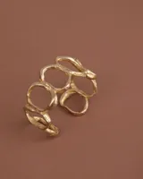 Brazalete dorado con diseño de círculos irregulares.