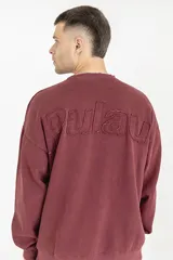 Buzo color bordó con cuello redondo y mangas largas. Estampado en la espalda con la palabra 'Pulau' en relieve.