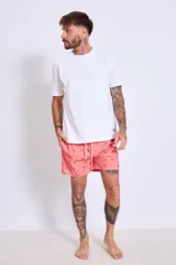 Short de baño celeste con estampado de gaviotas en negro y etiqueta con logo en la pierna.