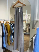 Vestido largo de lino color crudo, con escote halter fruncido y abertura lateral en la falda.